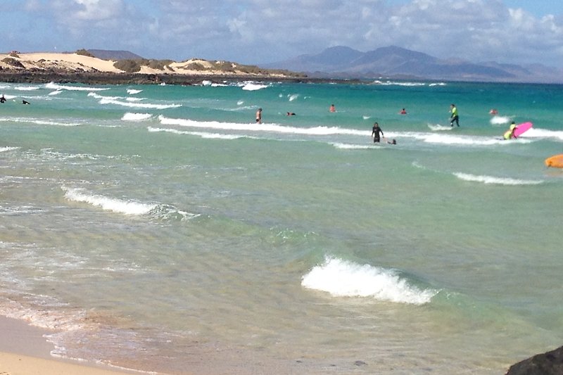 Una vista mozzafiato sulla costa con spiaggia di sabbia bianca e onde che si infrangono sull'oceano.