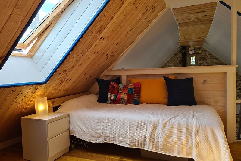 Gemütliches Schlafzimmer mit stilvollem Interieur und Holzbalken.