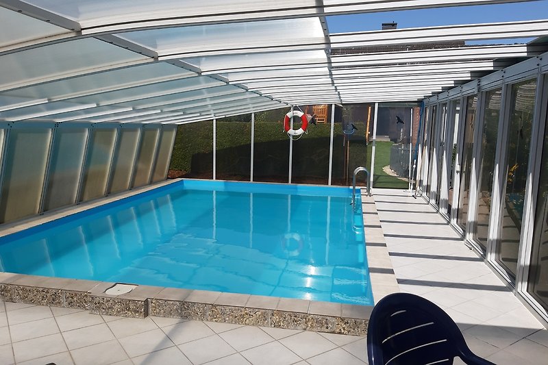 Moderne Ferienwohnung mit Pool, Sonnenliegen und Blick aufs Wasser.