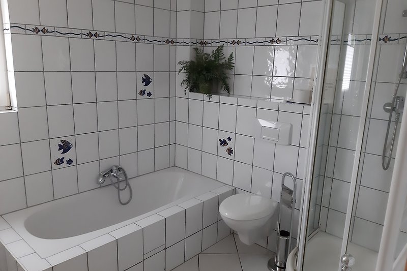 Ein modernes Badezimmer mit Badewanne und Dusche.