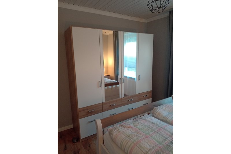 Modernes Schlafzimmer mit elegantem Holzbett und stilvoller Inneneinrichtung.