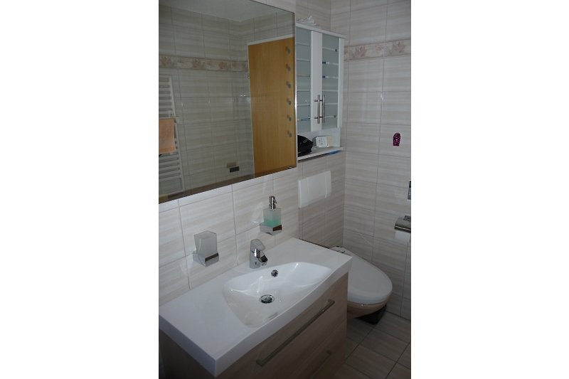 Badezimmer mit Badewanne, Waschtisch, WC inkl. Bidetfunktion.