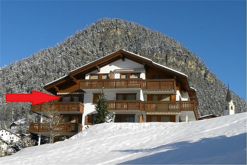 Gemütliches Ferienhaus mit Bergpanorama und verschneiter Landschaft.