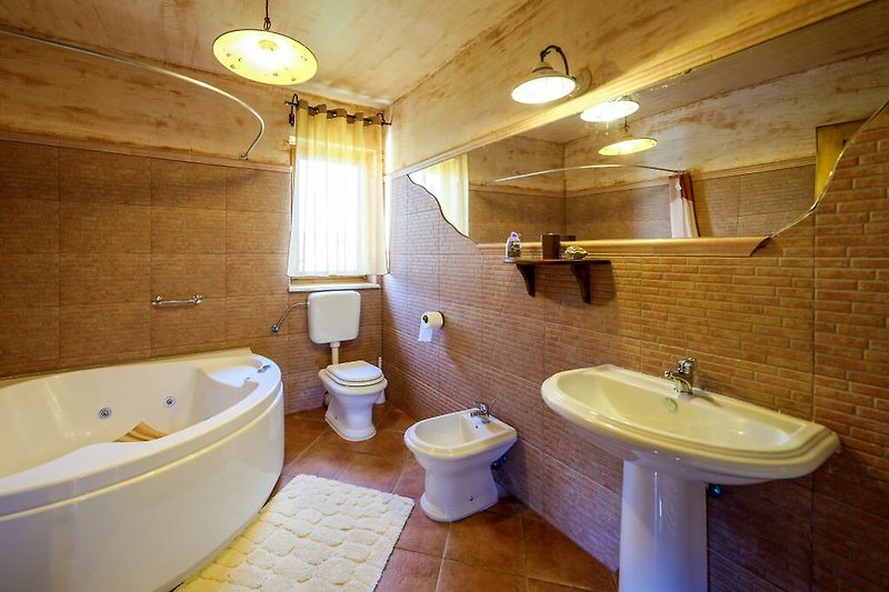 Schönes Badezimmer mit Spiegel, Badewanne und Waschbecken.