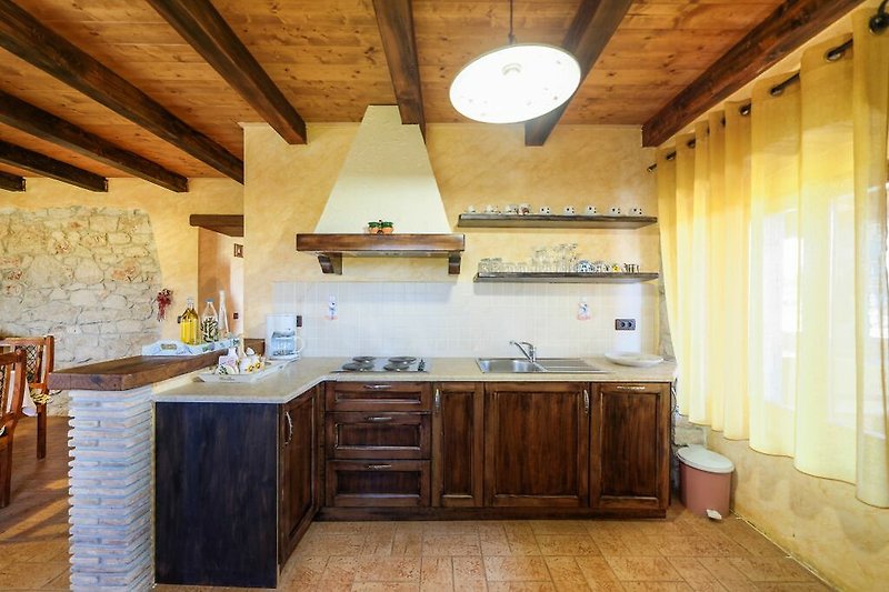 Moderne Küche mit Holzmöbeln, Fenster und stilvoller Einrichtung.