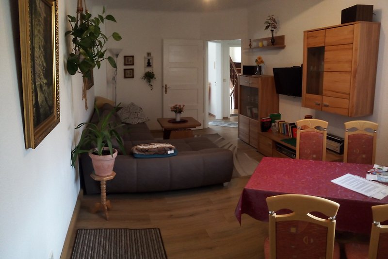 Wohnzimmer mit Schrankwand Doppelbettcouch Essecke und TV