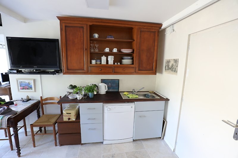 Moderne Küche mit hochwertigen Geräten und Holzmöbeln.