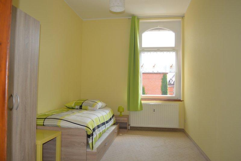 Schlafzimmer 2 mit stilvollem Fenster und gemütlichem Bett.