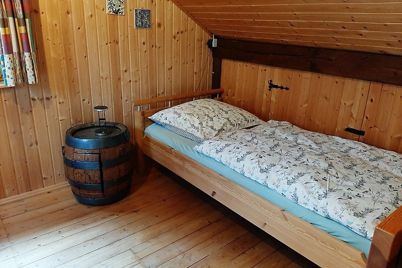 Schlafzimmer mit Holzbett und Fenster. Gemütliche Atmosphäre.
