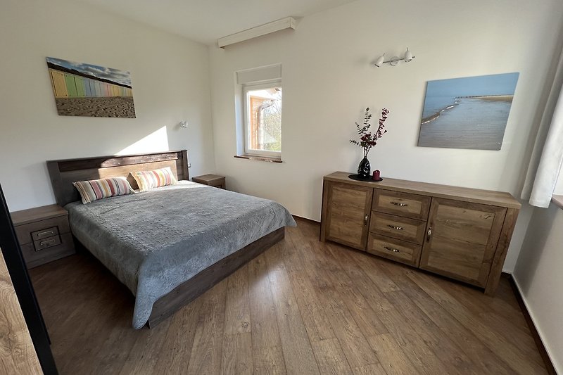 Gemütliches Schlafzimmer mit Holzmöbeln und viel Licht.