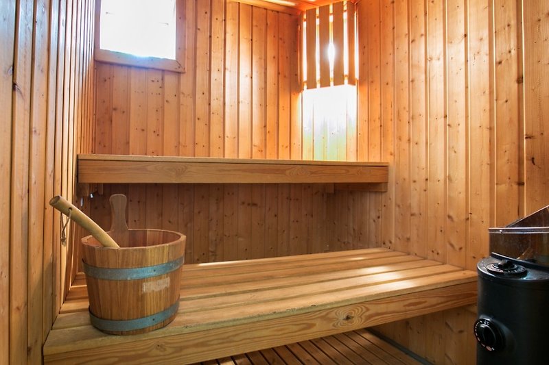 Holzhaus mit stilvollem Interieur, Sauna und gemütlicher Beleuchtung.