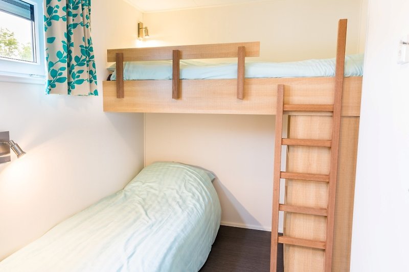 Komfortables Schlafzimmer mit stilvoller Einrichtung und Holzboden.