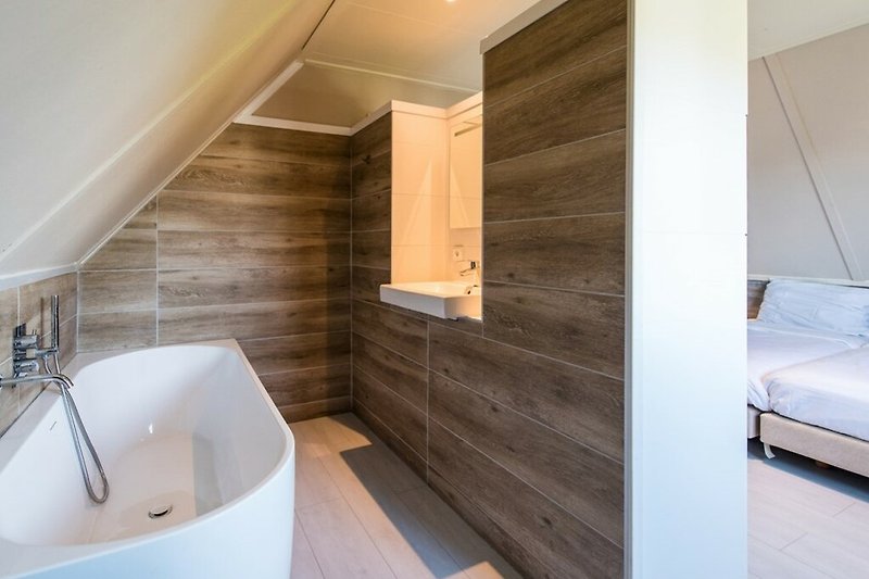 Schönes Badezimmer mit Holzboden und stilvoller Armatur.