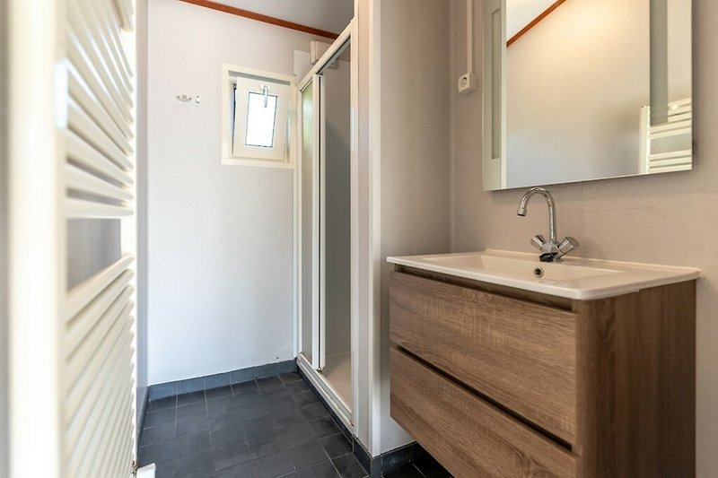 Schönes Badezimmer mit modernem Waschbecken und Spiegel.