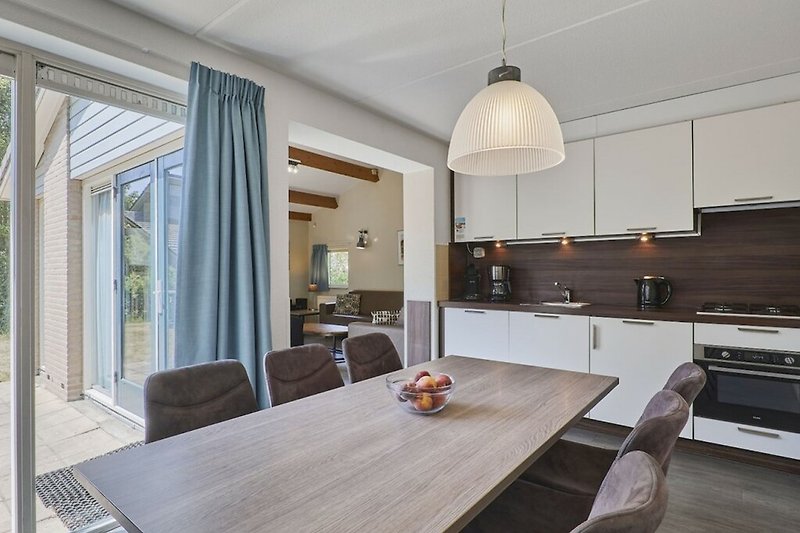 Moderne Küche mit Holzmöbeln und grauem Bodenbelag.