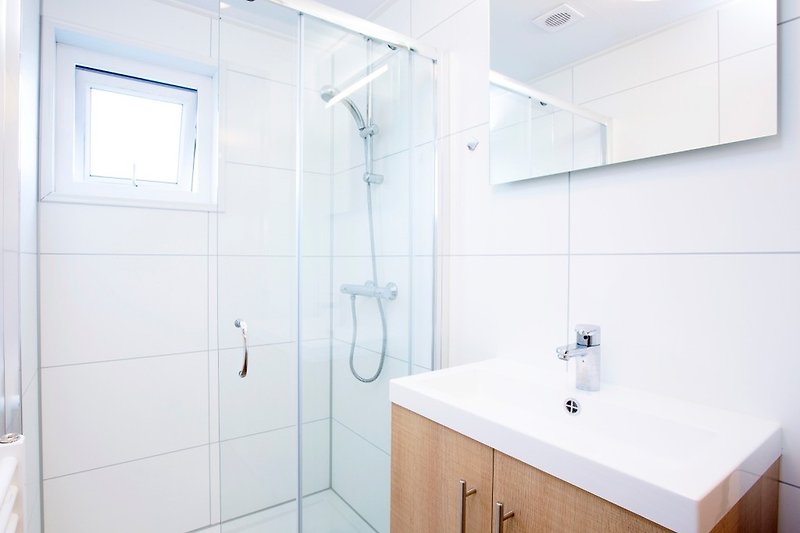 Modernes Badezimmer mit stilvoller Einrichtung und Glasdusche.