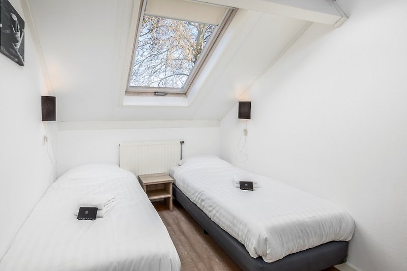 Gemütliches Schlafzimmer mit bequemem Bett und stilvollem Fenster.