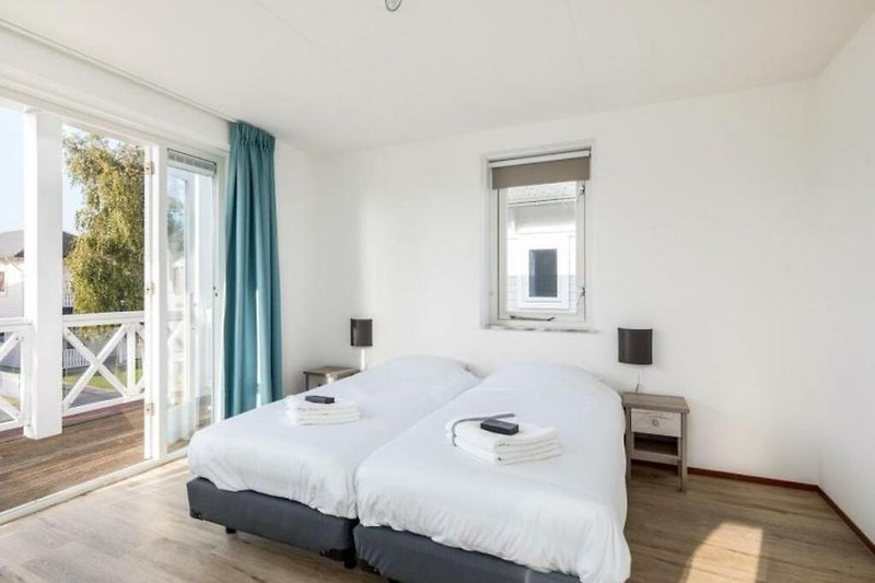 Schönes Schlafzimmer mit Holzboden, gemütlichem Bett und Fenster.
