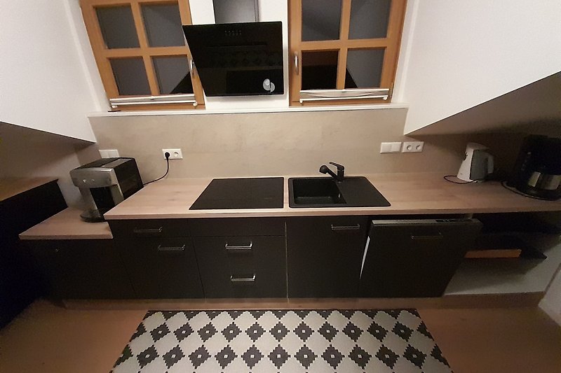 Schicke Küche mit schwarzen Holzschränken und stilvollen Details.