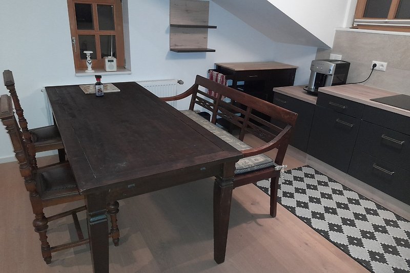 Schöner Holztisch mit stilvollen Möbeln und einer Küchenzeile.