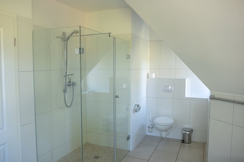 Schönes Badezimmer mit Dusche, Duschkopf und modernen Armaturen.
