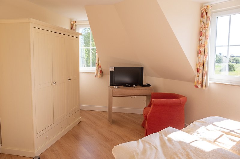 Gemütliches Schlafzimmer II mit bequemem Boxspring-Betten, stilvollem Holzboden und Fernseher