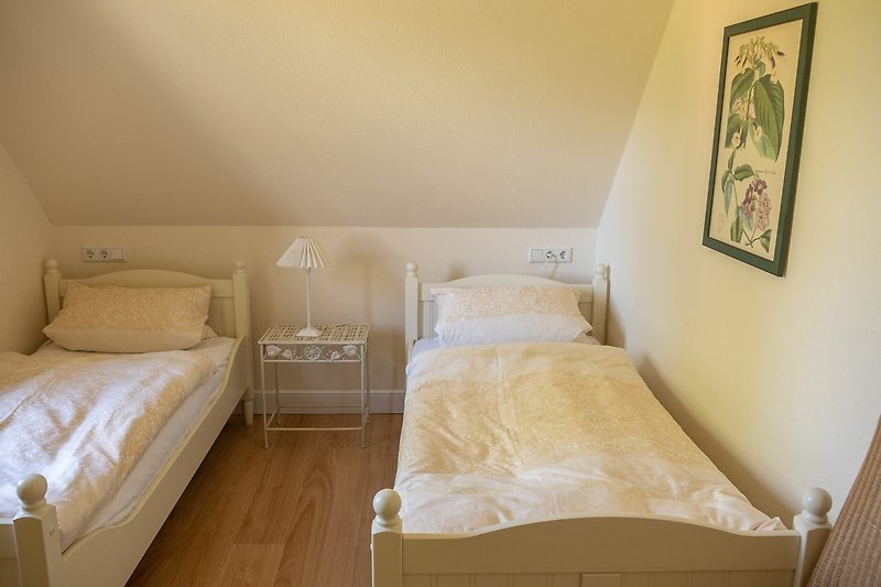 Gemütliches Schlafzimmer I mit bequemem Einzelbetten, Holzboden und stilvoller Beleuchtung.