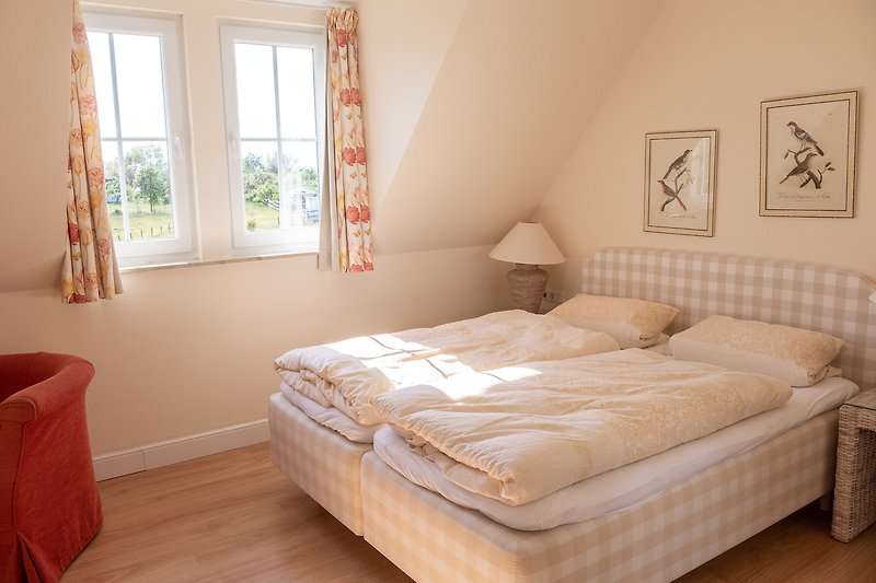 Gemütliches Schlafzimmer II mit bequemem Boxspring-Betten, stilvollem Holzboden und angenehmer Beleuchtung.