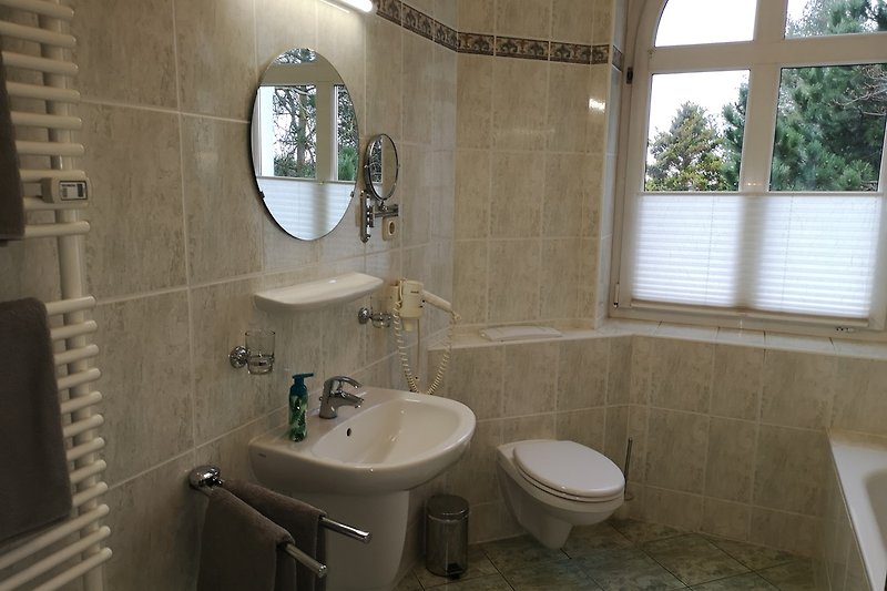 Modernes Badezimmer mit lila Fliesen und Fenster.