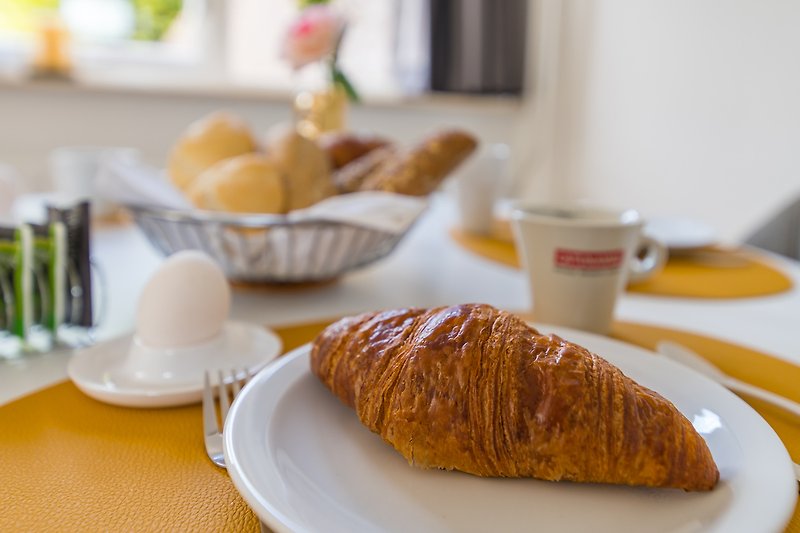 Ontbijttafel met croissants, verse eieren van de boer en broodjes. Lokale producten voor een smakelijk ontbijt.