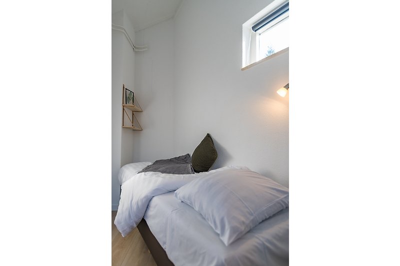 Elegante slaapkamer met comfortabele boxspringbedden en bedlampjes.