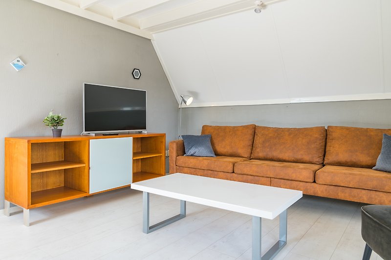 Mooi ingerichte woonkamer met comfortabele bank en smart-tv.