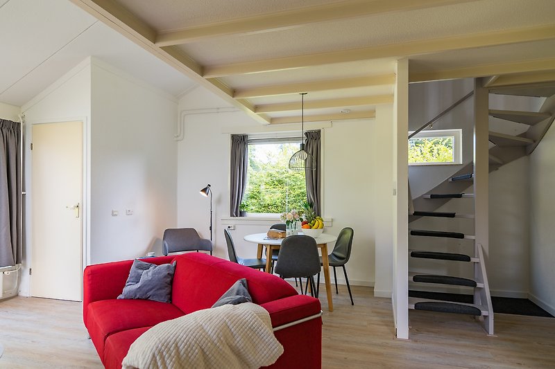 Stijlvolle woonkamer met comfortabele bank en moderne inrichting en semi-geschermde trap naar boven