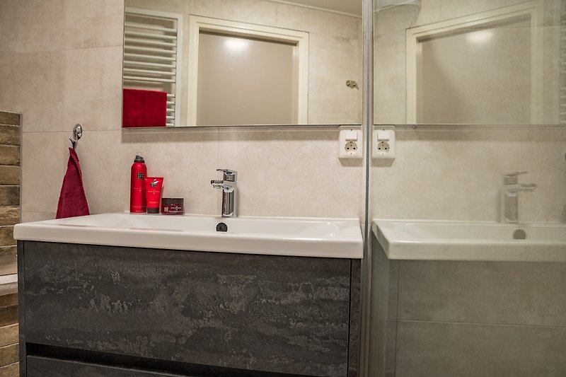 Luxe badkamer met handdoeken en haardroger in het wastafelmeubel