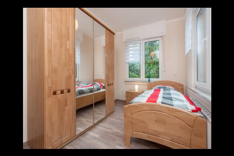 Schlafzimmer 3: Gemütliches Schlafzimmer mit Holzmöbeln und bequemem Bett.