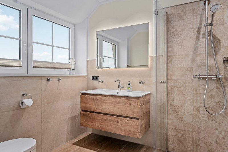 Schönes Badezimmer 2 mit Spiegel, Waschbecken und Fenster.