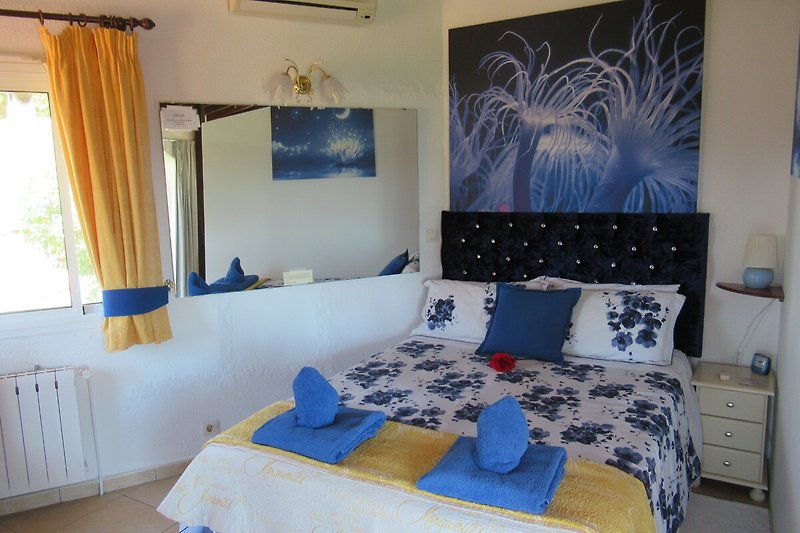 A stylish bedroom with comfortable furniture and blue accents. with  a  150cm bed.