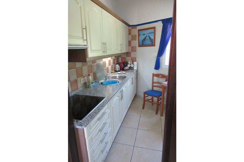 A well equipped kitchen with Fridge freezer, Microwave, hob, kettle, coffee machine. also seating area.