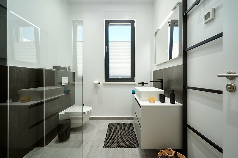 Ein modernes Badezimmer mit stilvoller Einrichtung und hellem Holzboden.