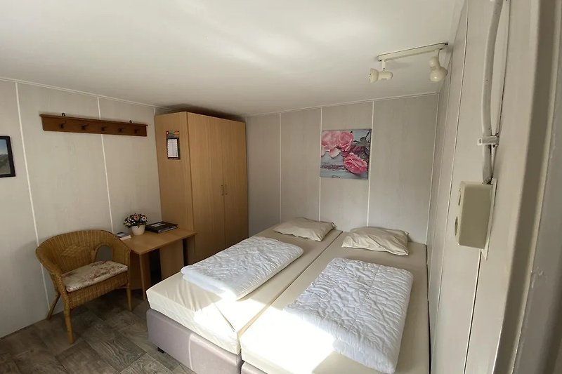 Comfortabele slaapkamer met houten meubels en zachte beddengoed.