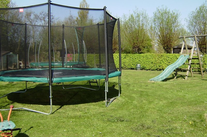 Prachtige tuin met speeltuin, trampoline en schommel.