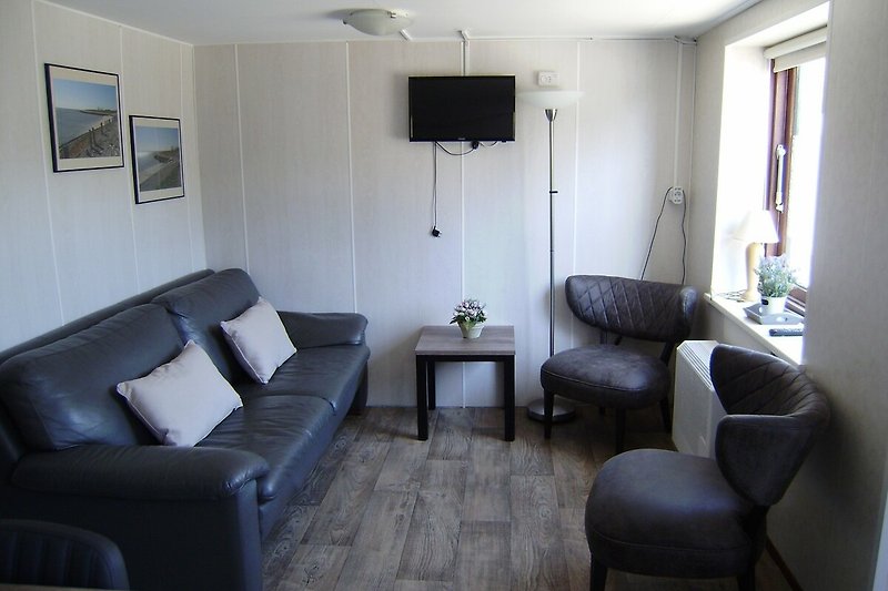 Comfortabele woonkamer met houten meubels en sfeervolle verlichting.