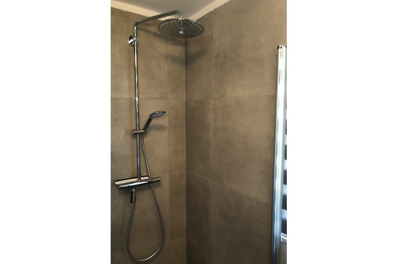 Prachtige badkamer met moderne verlichting, toilet en keramische tegels.