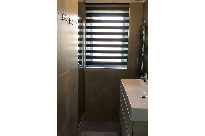 Fraaie badkamer met keramiosche tegels en heerlijke douche