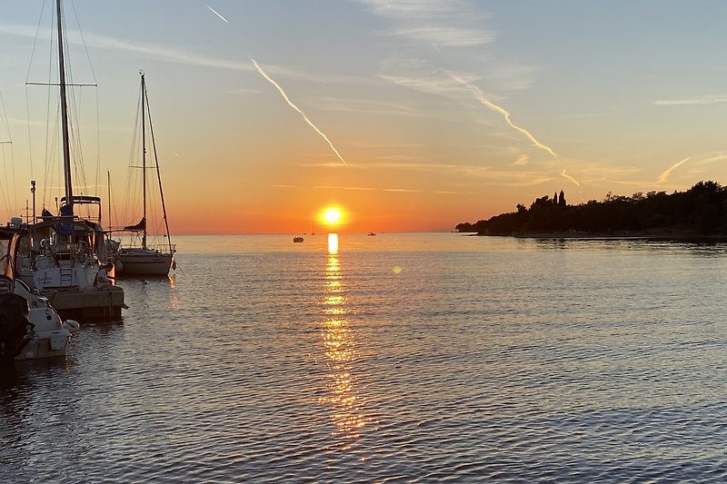 Wunderschöner Sonnenuntergang über dem ruhigen Wasser mit Boot.