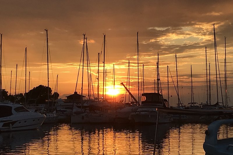 Ein Boot segelt auf dem ruhigen Wasser bei Sonnenuntergang.