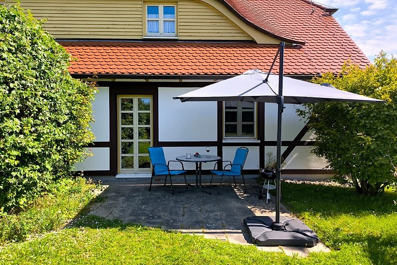 Einladende Terrasse mit Gartenmöbeln und gepflegtem Rasen.