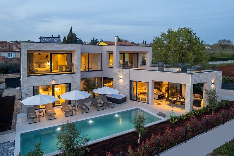 Luxuriöse Villa mit Pool, grüner Landschaft und stilvollem Design.
