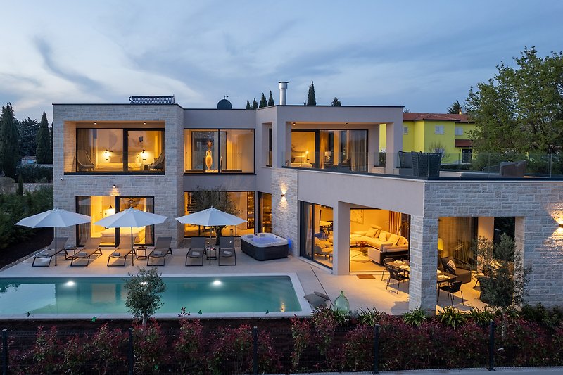 Luxuriöses Anwesen mit Pool, grüner Landschaft und modernem Design.