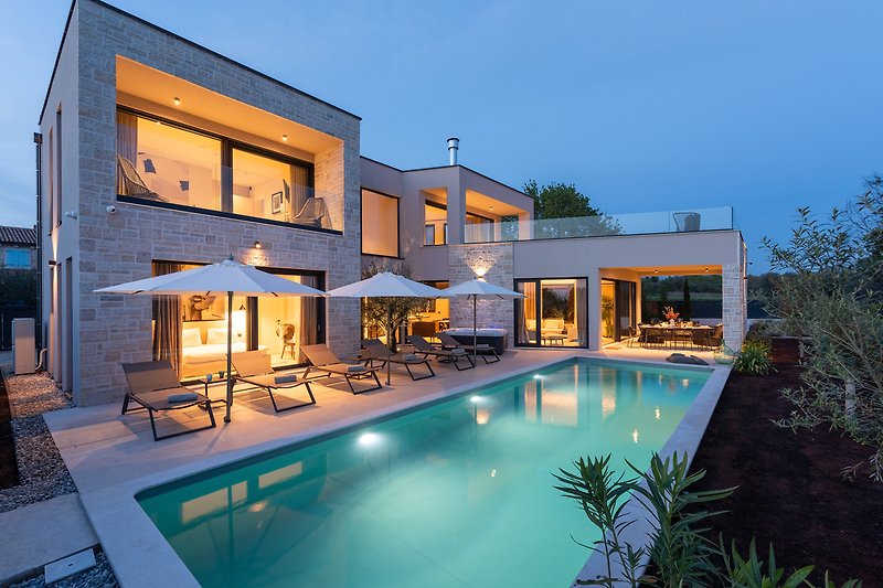 Moderne Villa mit Pool Blick auf die grüne Landschaft.